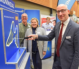 Am Stand der Provinzial probierte Bürgermeister Dirk Woschei (rechts) das Geschicklichkeitsspiel "Heißer Draht" aus. Die Versicherungsberater Jens Kratzer und Angela Huckfeldt begutachteten sein Können. (Foto: Frank)