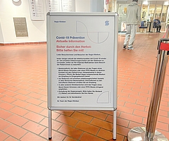 Auf einem Aufsteller im Eingangsbereich der Regio-Kliniken werden die aktuellen Corona-Regeln erläutert. (Foto: Regio Kliniken)