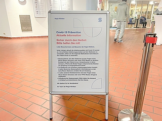 Auf einem Aufsteller im Eingangsbereich der Regio-Kliniken werden die aktuellen Corona-Regeln erläutert. (Foto: Regio Kliniken)