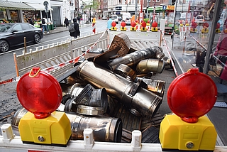 Am Morgen nach dem Brand liegen die Reste des Rauchabzugs auf dem Bürgersteig an der Königstraße. Ein Mitarbeiter des Bauhofs stellte davor Baustellenzäune auf. Die Polizei spannte ein rot-weißes Flatterband auf. Daran hängt der Hinweis, dass das Material beschlagnahmt ist. (Foto: Frank)