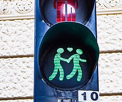 Diese Fußgängerampel in Wien zeigt oben zwei Männer, die sich bei Rot umarmen, und unten zwei Männer, die bei Grün Hand in Hand gehen. Zwischen ihnen schwebt ein leuchtendes Herz. (Foto: Björn Hildebrand)