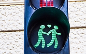 Diese Fußgängerampel in Wien zeigt oben zwei Männer, die sich bei Rot umarmen, und unten zwei Männer, die bei Grün Hand in Hand gehen. Zwischen ihnen schwebt ein leuchtendes Herz. (Foto: Björn Hildebrand)