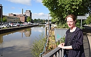 Die städtische Wasserbauingenieurin Sabine Landt steht auf der Wedenkampbrücke am Nordufer des Elmshorner Hafens. Unterhalb der Brücke ist die marode Spundwand und dahinter die Museumswerft des Ewer „Gloria“ zu sehen. (Foto: Jan-Hendrik Frank)