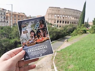 „Von der Flüchtigkeit eines Geschmacks“ gewann in der Kategorie „Best Fiction“. Produzent Gerrit Gronau flog zur Preisverleihung nach Rom – und schoss dieses Bild seines Film-Flyers vor ikonischer Kulisse. (Foto: Gronau)