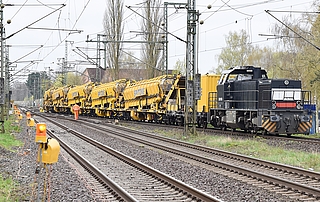 Die Rottenwarnanlage (vorn) besteht aus einer Reihe von Warnlampen und Signalhörnern, die über mehrere hundert Meter neben den Gleisen aufgestellt wurden. Der gelbe Spezialzug transportiert bei den Gleisarbeiten entstandenen Bauschutt Richtung Norden. Das Bild entstand an Gleis 1 des Elmshorner Bahnhofs. (Foto: Frank)