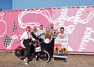 Laden zum ersten Elmshorner Feierabend-Markt ein: „klaun A“ alias Almuth Evers (von links), Wiebke Läu vom Stadtmarketing, Tim Ahrens von Hamke Event & Messe, Malin Waldow und Ralf Hots-Thomas vom Stadtmarketing sowie Marktmeisterin Alexandra Eltze. (Foto: Frank)