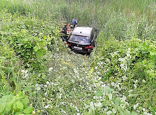 Das Auto landete in einem versumpften Regenrückhaltebecken. Angehörige stiegen hinab, um nach dem Zustand des Wagens zu sehen. (Foto: Frank)