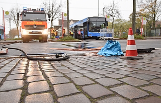 Am Elmshorner ZOB liefen mehrere Liter Dieselkraftstoff aus dem Tank eines Linienbusses in Richtung eines Gullys, vor dem deshalb eine Sandsperre angelegt wurde. (Foto: Frank)