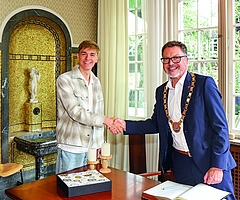 Handschlag und Austausch unter Sportlern. Johannes Liebmann und Oberbürgermeister Erik Sachse beim Empfang in der Weißen Villa. Vorn das Goldene Buch der Stadt Elmshorn. (Foto: Strandmann)