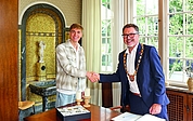 Handschlag und Austausch unter Sportlern. Johannes Liebmann und Oberbürgermeister Erik Sachse beim Empfang in der Weißen Villa. Vorn das Goldene Buch der Stadt Elmshorn. (Foto: Strandmann)