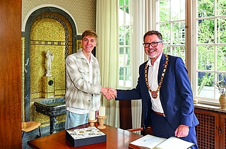Handschlag und Austausch unter Sportlern. Johannes Liebmann und Oberbürgermeister Erik Sachse beim Empfang in der Weißen Villa. Vorn das Goldene Buch der Stadt Elmshorn. (Foto: Strandmann)