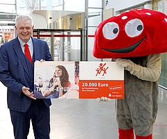 Ansgar Menke, Vorstandsvertreter der Sparkasse Südholstein, und Glückspilz „Lotti“ – das Maskottchen des Los-Sparens der Sparkassen – rufen zur Bewerbung für die Aktion „20 für 20“ auf“. (Foto: Sparkasse Südholstein)