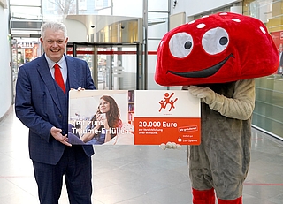 Ansgar Menke, Vorstandsvertreter der Sparkasse Südholstein, und Glückspilz „Lotti“ – das Maskottchen des Los-Sparens der Sparkassen – rufen zur Bewerbung für die Aktion „20 für 20“ auf“. (Foto: Sparkasse Südholstein)