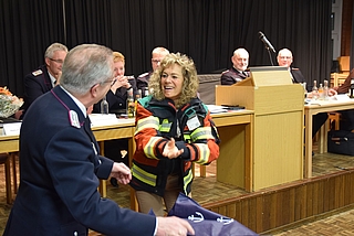 Hans Joachim Mölln, stellvertretender Wehrführer der Ortsfeuerwehr Ahrenlohe, überreichte Bürgermeisterin Sabine Kählert eine Schutzjacke. (Foto: Frank)