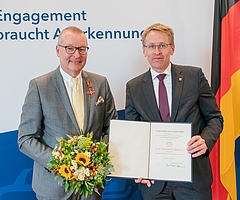 Feierlich: Ministerpräsident Daniel Günther (rechts) überreichte Axel Vogt das Verdienstkreuz am Bande des Verdienstordens der Bundesrepublik Deutschland. (Foto: Kreis Pinneberg)