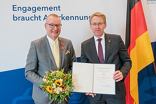 Feierlich: Ministerpräsident Daniel Günther (rechts) überreichte Axel Vogt das Verdienstkreuz am Bande des Verdienstordens der Bundesrepublik Deutschland. (Foto: Kreis Pinneberg)