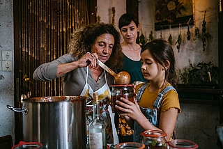 Szenenfoto aus dem Kurzfilm „Von der Flüchtigkeit des Geschmacks“: Großmutter Guiseppa (v. links, gespielt von Adriana Altaras), ihre Schwiegertochter Antonia (Anna Schumacher) und Enkelin Félie (Annabell Wessel) müssen verarbeiten, dass der Vater der Achtjährigen gestorben ist, und neu zueinander finden. (Foto: Sara Herrlander)