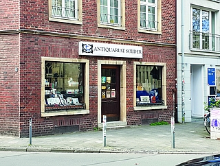 Dieses Antiquariat in Münster bildet den Ausgangspunkt zahlreicher Ermittlungen von Georg Wilsberg. In den TV-Produktionen prangt natürlich ein anderer Schriftzug darüber. (Foto: Strandmann)