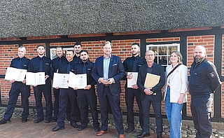 Feierten den erfolgreichen Abschluss der Ausbildung: Justizstaatssekretär Otto Carstens (Siebter von links), Stefan Ruppert (Neunter von links, Leiter der Abschiebungshafteinrichtung Glückstadt), Johanna Hampel (Mitarbeiterin im Justizministerium), Alex Krug (rechts, Ausbildungsleiter der Abschiebungshafteinrichtung Glückstadt) und die neuen Mitarbeiter der neuen Abschiebehafteinrichtung Glückstadt. (Foto: Ministerium für Justiz und Gesundheit)