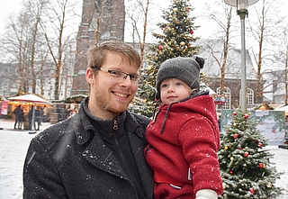 Marten Moraal und seine Tochter genießen den Schnee vor der Nikolai-Kirche in Elmshorn. (Foto: Jan-Hendrik Frank)