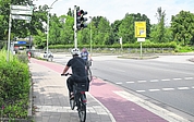 Die Einmündung Hamburger Straße/Ecke Steindamm in Elmshorn: Die Radlerin, deren Rücken zu sehen ist, fährt gegen die erlaubte Fahrtrichtung. Bei solchen Geisterfahrern erwecken die Schilder am linken Bildrand allerdings den Eindruck, auf einem offiziellen Radweg unterwegs zu sein. Sie weisen auf Radwege nach Itzehoe, Barmstedt, Seestermühe, Seester, zum Bahnhof und ins Zentrum hin. Auch der Ochsenweg quert hier die Hamburger Straße. (Foto: Frank)