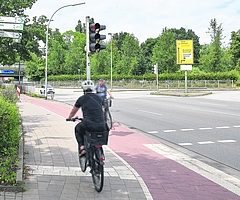 Die Einmündung Hamburger Straße/Ecke Steindamm in Elmshorn: Die Radlerin, deren Rücken zu sehen ist, fährt gegen die erlaubte Fahrtrichtung. Bei solchen Geisterfahrern erwecken die Schilder am linken Bildrand allerdings den Eindruck, auf einem offiziellen Radweg unterwegs zu sein. Sie weisen auf Radwege nach Itzehoe, Barmstedt, Seestermühe, Seester, zum Bahnhof und ins Zentrum hin. Auch der Ochsenweg quert hier die Hamburger Straße. (Foto: Frank)