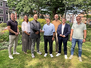 Handschlag auf die neue Kooperation: Daniel Liedtke (von links, Stadt Elmshorn), Anke Bokelmann-Janssen (Stadt Elmshorn), Michael Leeske (Stadt Elmshorn), Amedeus Hajek (AlsterFood GmbH), Alexander Philipp (AlsterFood GmbH), Daniel Faron (Stadt Elmshorn) und Pascal Mann (AlsterFood GmbH). (Foto: Stadt Elmshorn/Torben Webb)