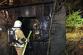 Einsatzkräfte kontrollieren eine ausgebrannte Hütte. (Foto: Kreisfeuerwehrverband Pinneberg)