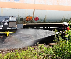 Die Elmshorner Wehr beim Löschen und Kühlen der heiß gelaufenen Bremse. Das Schild am Zug zeigt: Der Waggon könnte gefährliche Ladung enthalten. Foto: Strandmann