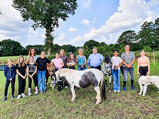 Das Projekt „Pferdeführerschein“ führte sie zusammen: Die Erwachsenen Kerstin Boos und Jil Nielsen vom Team Ganztag KGSE (v. l.), Britta Sey (Trainerin Reittherapie), Rolf Heidenberger (Vorsitzender Stiftung „Appen musiziert“), Sibylle Kumm (Trainerin), die Mädchen der KGSE sowie die Ponys Pico, Pinky und Pucky und Hund Lyo. (Foto: Stadt Elmshorn)