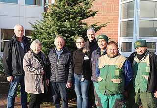 Zur Adventszeit sind die Spender nahezu rund um die Uhr damit beschäftigt, Weihnachtsbäume auszuliefern. Das Foto zeigt daher die Spendenübergabe 2022:  Rolf Thies (von links), Bärbel Maurer (FKE), Reinhard Boltzen, Anne Brüdgam (Regio Klinikum), Holger Niemann (FKE) sowie drei Mitarbeiter des GaLa-Bau-Betriebes Hartmut Will. (Foto: Förderverein für Menschen im Krankenhaus Elmshorn)