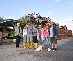 Halten zusammen: Matthias Kraemer (von rechts), Christine Lehmitz, Ute May mit ihrem Hund Fiete, Melanie, Oliver und Emma Seeliger stehen vor den verkohlten Resten ihres geliebten Zuhauses in Moorrege am Deichweg. Bürgermeister Wolfgang Balasus organisiert Hilfen für die Familien. (Foto: Frank)