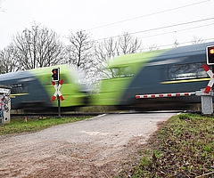 Ein Zug rauscht durch den Bahnübergang Neuendeicher Weg. Auf dieser Strecke fallen im Juli viele Verbindungen aus. (Archiv: Frank)