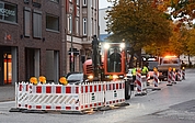 Der Linksabbieger von der Schul- in die Holstenstraße ist gesperrt. Ein Baggerfahrer stemmt den Asphalt auf. (Foto: Frank) 
