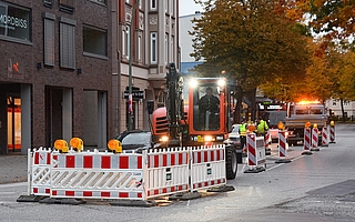 Der Linksabbieger von der Schul- in die Holstenstraße ist gesperrt. Ein Baggerfahrer stemmt den Asphalt auf. (Foto: Frank) 