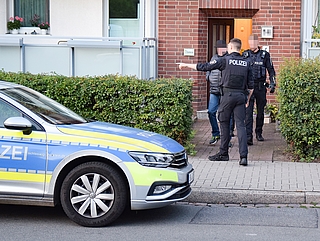 Die Polizei verlässt zusammen mit dem Verdächtigen das Mehrfamilienhaus, aus dem heraus die Schüsse gefallen sein sollen. (Foto: Frank)
