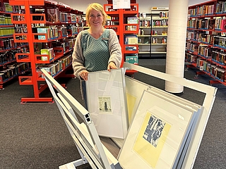 Heidi Sowada von der Stadtbücherei präsentiert einen Druck aus der Artothek. (Foto: J. Schmelzer, Stadtbücherei Elmshorn)