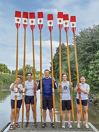 Diese Riemen hatte der Elmshorner Ruder-Club (ERC) dem Film-Team zur Verfügung gestellt. Die Crew ließ die ERC-Vereinsfarben Blau und Weiß mit der rot-weißen kanadischen Flagge übermalen. Nach dem Dreh erhielt der Verein die Requisiten zurück. Petra Westphal (von links) aus der Vereinsverwaltung, die Jugendtrainer Annika Bunk, Florian Busch und Frederik Seidel sowie Jugendleiterin Finja Westphal präsentieren sie auf einem Bootssteg an der Krückau. (Foto: Peter Westphal)