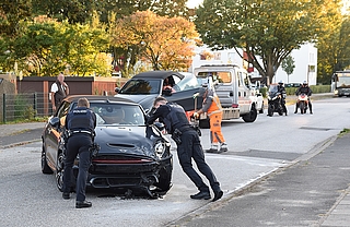 Zwei Polizeibeamte versuchten, einen Mini Cooper an den Straßenrand zu schieben, doch der Wagen bewegte sich nicht. (Foto: Frank)