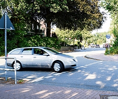 Ein Auto biegt von der Ahrenloher Straße in die Hamburger Straße ab. Radfahrende und Fußgänger haben auf diesem Überweg Vorrang. Das ist laut Gesetz aber nicht erlaubt, da die Querung mehr als fünf Meter von der Ahrenloher Straße entfernt liegt. (Foto: Frank)