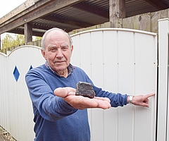 Wilfried Labusch zeigt den Meteoriten und die Stelle, an der das außerirdische Gestein seinen Metallzaun beschädigte. (Foto: Frank)